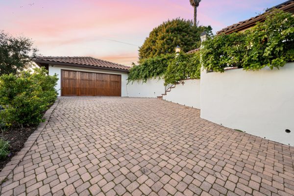 Brick paver driveway leading to a garage