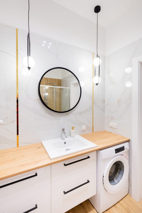 Stylish bathroom with round mirror and marble wall.
